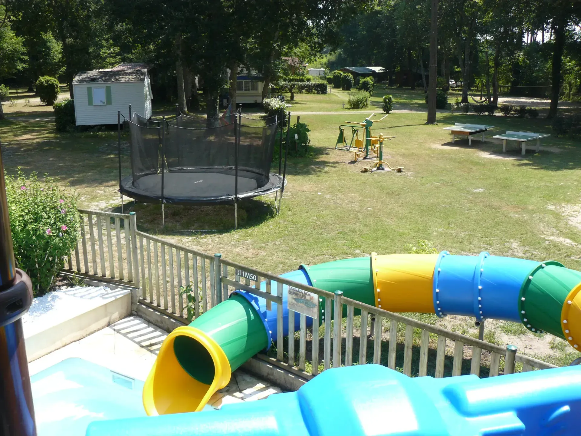 Toboggan aquatique coloré près de l'aire de loisirs arborée du camping à Saint-Justin