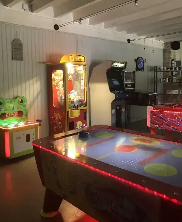 Salle de jeux avec air hockey, fléchettes et jeux d’arcade